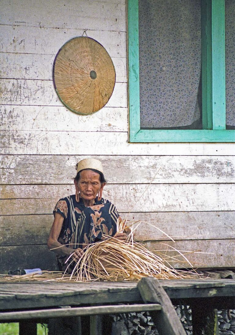 Dayak vrouw, riet vlechtend