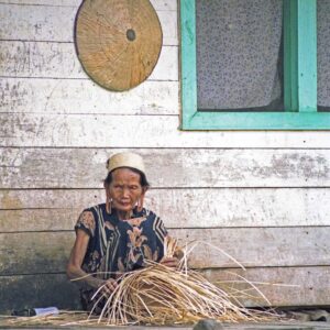 Dayak vrouw, riet vlechtend